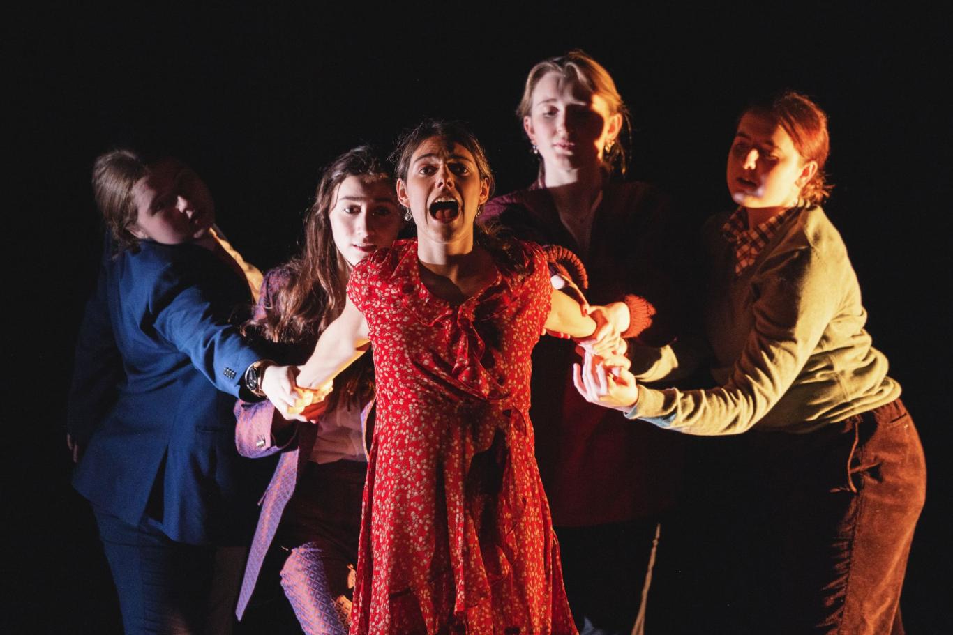 Four students hold the arms of a fifth student, who leans forward shouting towards the audience, during a CLC production of 'Things I Know to be True'