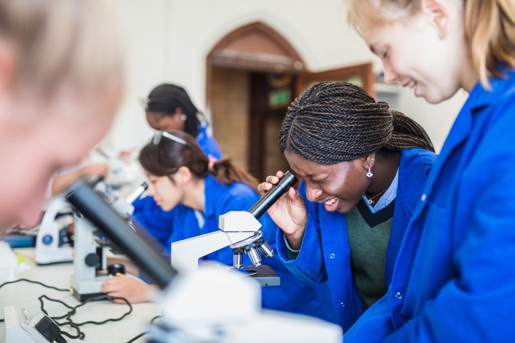A sixth from student looks into a microscope during a chemistry lesson in the newly refurbished science lab at Cheltenham Ladies' College