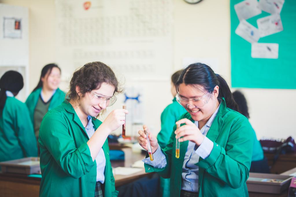 Two UC4 (Year 10) CLC students hold three test tubes using an experiment in their chemistry lesson.