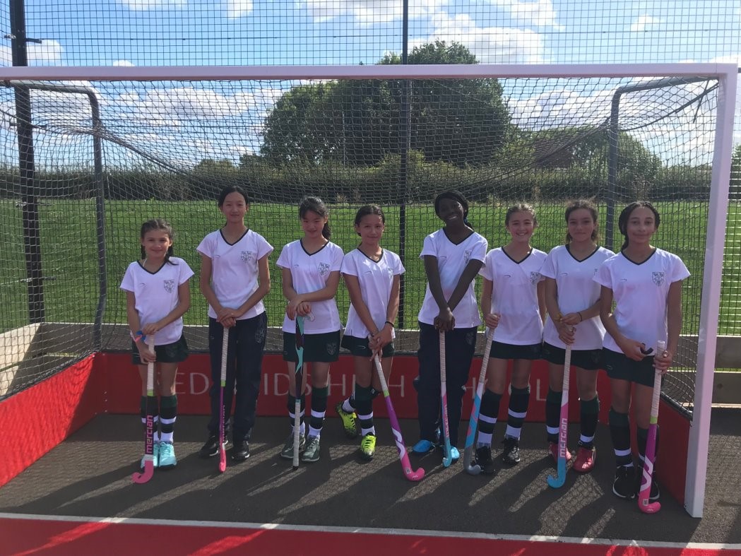 Seven Year 7 hockey players standing in the goal with their sticks